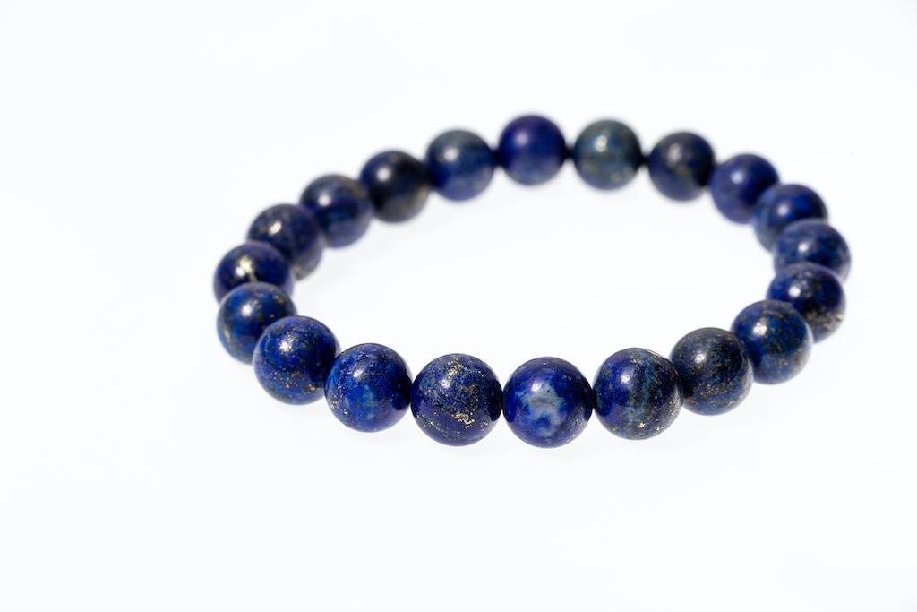 Un bracelet de perles de lapis lazuli sur fond blanc