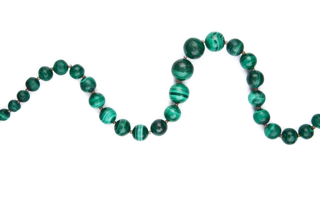 Des perles de malachite sur fond blanc