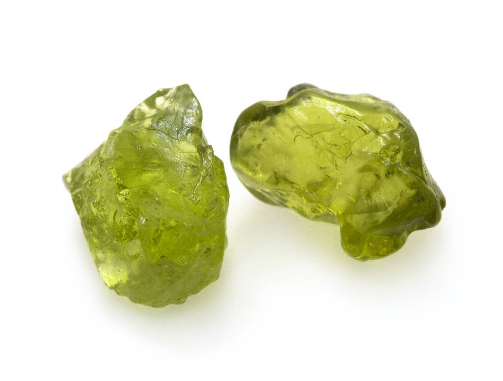 Deux pierres de peridot bruts sur fond blanc