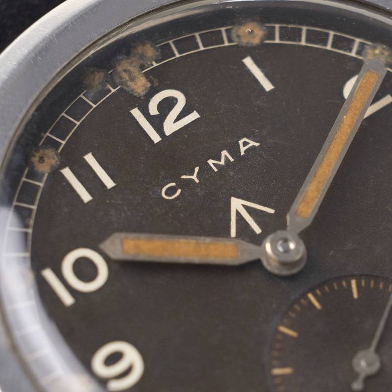 Insigne Broad Arrow sur cadran de montre Cyma (Source : Bulang and Sons EU)