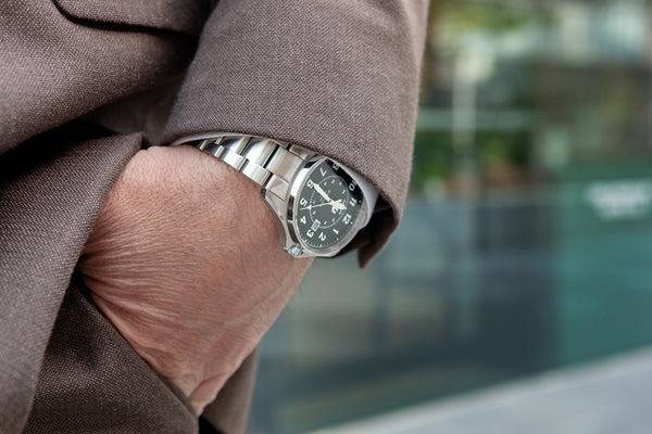 Montre militaire Wasson portée avec un costume (Source : Wasson Watch Co.)